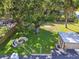 Expansive backyard featuring a stone fire pit, storage shed, mature shade trees and fenced play area at 4009 S Renellie Dr, Tampa, FL 33611