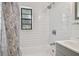 Subway-tiled shower and tub with a black framed window and modern fixtures in a neutral setting at 4009 S Renellie Dr, Tampa, FL 33611