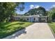 Charming single-story home featuring a bright blue door and a covered parking area with a concrete driveway at 4009 S Renellie Dr, Tampa, FL 33611