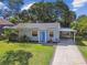 Charming single-story home with a blue front door, manicured lawn, and covered parking at 4009 S Renellie Dr, Tampa, FL 33611