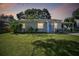 Charming single-story home at dusk featuring a bright blue door, covered parking, and a well-manicured lawn at 4009 S Renellie Dr, Tampa, FL 33611