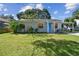 Charming single-story home featuring a bright blue door, covered parking, and a well-manicured lawn at 4009 S Renellie Dr, Tampa, FL 33611