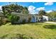 Charming single-story home featuring a bright blue door, covered parking, and a well-manicured lawn at 4009 S Renellie Dr, Tampa, FL 33611