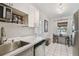 Well-lit kitchen with stainless steel appliances, white cabinetry, and a dining table nearby at 4009 S Renellie Dr, Tampa, FL 33611