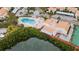 Aerial view of a pool and spa area surrounded by tropical landscaping, a boat dock and residential buildings at 4214 Harbor House Dr, Tampa, FL 33615