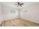 A cozy bedroom with wood-look flooring, two windows, and a ceiling fan at 4414 W Oklahoma Ave, Tampa, FL 33616