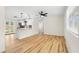 Well-lit living room with hardwood floors and an open concept view of the modern kitchen at 4414 W Oklahoma Ave, Tampa, FL 33616