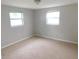 Bedroom with neutral carpeting and two windows at 4417 Kohler St, New Port Richey, FL 34652