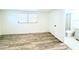 Bright bedroom with hardwood floors, large window, and an adjacent bathroom at 4638 Durney St, New Port Richey, FL 34652
