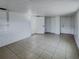 Open living room with neutral tile floors, white walls, and multiple access doors for easy flow at 4638 Durney St, New Port Richey, FL 34652