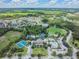Aerial view displays the community's picturesque lakes, ample green spaces, pools, clubhouse, and tennis courts at 4716 Butler National Dr, Wesley Chapel, FL 33543