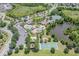Aerial view showcases community amenities including pools, clubhouse, basketball court, tennis courts, and waterways at 4716 Butler National Dr, Wesley Chapel, FL 33543