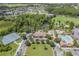 An aerial view of the community clubhouse, pools, and recreation areas nestled amidst trees and surrounding ponds at 4716 Butler National Dr, Wesley Chapel, FL 33543