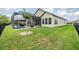 Lush backyard features a screened-in patio and offers an inviting outdoor living experience at 4716 Butler National Dr, Wesley Chapel, FL 33543