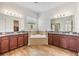 Spacious bathroom featuring dual sinks, granite countertops, a soaking tub, and wood-look floors at 4716 Butler National Dr, Wesley Chapel, FL 33543