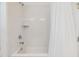 Bright bathroom with a white tiled shower, bathtub, and shower curtain at 4716 Butler National Dr, Wesley Chapel, FL 33543