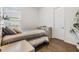 Neutral bedroom showcasing a modern bed set, wood-look flooring, and natural light at 4716 Butler National Dr, Wesley Chapel, FL 33543