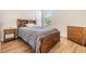 Comfortable bedroom featuring a cozy bed, wooden furniture, and wood-look flooring at 4716 Butler National Dr, Wesley Chapel, FL 33543