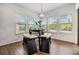 Bright dining area with a unique table and seating arrangement, flooded with natural light from large windows at 4716 Butler National Dr, Wesley Chapel, FL 33543