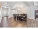 Open dining room with contemporary lighting, view to living room, and seating for eight people at 4716 Butler National Dr, Wesley Chapel, FL 33543