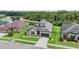 Inviting residence featuring a well-manicured lawn, lush landscaping, and a two-car garage at 4716 Butler National Dr, Wesley Chapel, FL 33543
