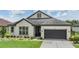 Lovely exterior with a well-manicured lawn, a two-car garage, and tasteful landscaping at 4716 Butler National Dr, Wesley Chapel, FL 33543