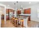 Spacious kitchen with stainless steel appliances, dark wood cabinets, an island with barstools, and granite counters at 4716 Butler National Dr, Wesley Chapel, FL 33543