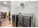 Well-equipped laundry room with modern washer and dryer on wood-look tile floors with storage at 4716 Butler National Dr, Wesley Chapel, FL 33543