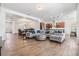 Open-concept living room featuring a gray sectional sofa, an accent ottoman, and an adjoined kitchen and dining room at 4716 Butler National Dr, Wesley Chapel, FL 33543
