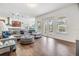 Bright open living space with wood-look floors and view to the covered lanai through sliding glass doors at 4716 Butler National Dr, Wesley Chapel, FL 33543