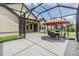 Spacious screened-in patio with an outdoor dining set is perfect for entertaining or relaxation at 4716 Butler National Dr, Wesley Chapel, FL 33543