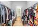 Spacious walk-in closet features wood-look tile flooring and plentiful storage racks on each side at 4716 Butler National Dr, Wesley Chapel, FL 33543