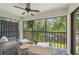 Screened balcony with seating area overlooking the trees and lake beyond at 4735 Winslow Beacon # 14, Sarasota, FL 34235