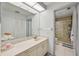 Bright bathroom showcasing a double vanity, large mirror, and a glass-enclosed shower at 4735 Winslow Beacon # 14, Sarasota, FL 34235