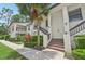 Exterior view of a charming condo building with a manicured lawn and mature palm trees at 4735 Winslow Beacon # 14, Sarasota, FL 34235