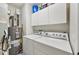Functional laundry area featuring a washer, dryer, water heater, and overhead cabinets for storage at 4735 Winslow Beacon # 14, Sarasota, FL 34235