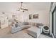 Open concept living room featuring a cozy gray sectional, fan, and bright natural light at 4735 Winslow Beacon # 14, Sarasota, FL 34235