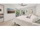 Spacious bedroom with a balcony, television, and comfortable furniture at 4735 Winslow Beacon # 14, Sarasota, FL 34235