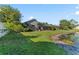 Spacious backyard with screened-in pool and spa, lush lawn and a serene pond at 4959 Felecity Way, Palm Harbor, FL 34685