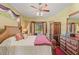 Main bedroom featuring canopy bed, ceiling fan and a sliding glass door to screened patio at 4959 Felecity Way, Palm Harbor, FL 34685