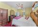 Main bedroom featuring canopy bed, ceiling fan and adjoining bathroom at 4959 Felecity Way, Palm Harbor, FL 34685