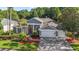 Charming home featuring a manicured front yard with lush landscaping, a two-car garage, and elegant architectural details at 4959 Felecity Way, Palm Harbor, FL 34685