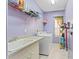 Well-lit laundry room featuring a washer, dryer, sink, and ample storage shelving at 4959 Felecity Way, Palm Harbor, FL 34685