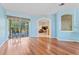 Spacious living room with wood floors and sliding glass doors leading to the outdoor pool area at 4959 Felecity Way, Palm Harbor, FL 34685