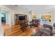 Inviting living room with hardwood floors, entertainment center, and leather couches leading to the kitchen at 4959 Felecity Way, Palm Harbor, FL 34685