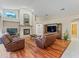 Cozy living room with a fireplace, wood floors, and comfortable leather furniture at 4959 Felecity Way, Palm Harbor, FL 34685