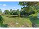Scenic view of a pond with green grass leading to the water's edge, framed by trees at 4959 Felecity Way, Palm Harbor, FL 34685