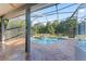 Relaxing screened-in pool and hot tub area with travertine tile and lush landscaping at 4959 Felecity Way, Palm Harbor, FL 34685