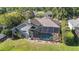 A lovely screened-in pool can be seen behind the home and next to a pond with lovely vegetation on top of the water at 4959 Felecity Way, Palm Harbor, FL 34685