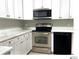 Well-lit kitchen showcases stainless steel appliances, white cabinets and hardware at 5203 Oak Charter Ct # 5203, Temple Terrace, FL 33617